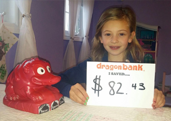 Child holding a sign that says how much they saved with DragonBank