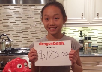 Child holding a sign that says how much they saved with DragonBank