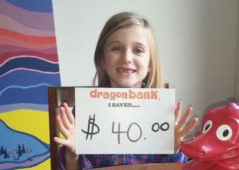 Child holding a sign that says how much they saved with DragonBank